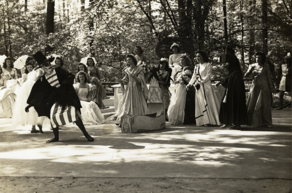 image of 1942 Performace during the May Day Festivities. Person in dark robe and stripes at far left, acting.
